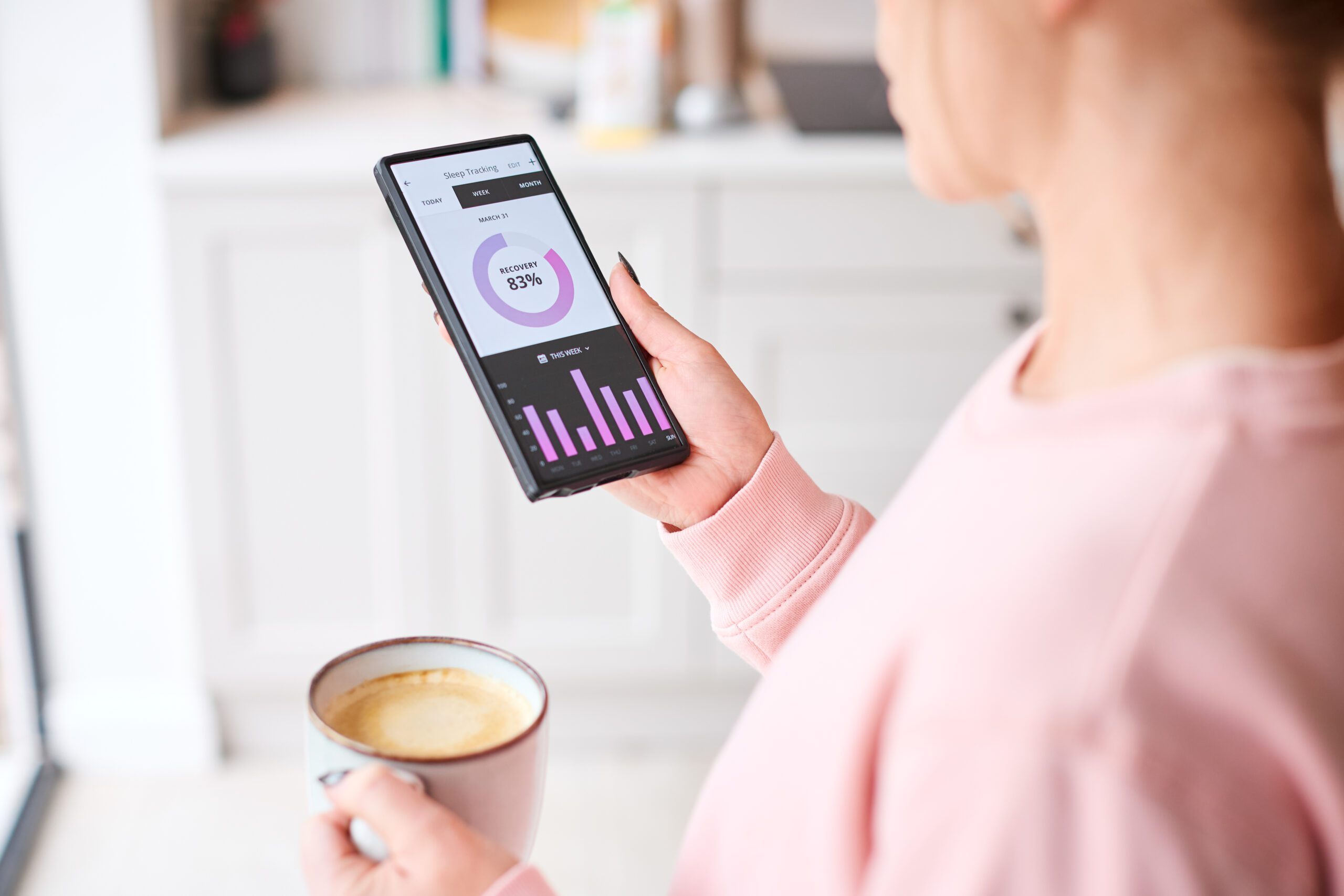 Close Up Of Woman Looking At Sleep Tracking App On Mobile Phone At Home